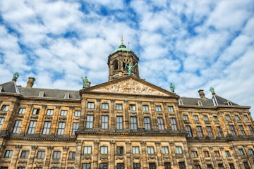 The Royal Palace in Amsterdam is situated in the west side of Dam Square in the centre of Amsterdam, Holland. Beautiful blue sky with cloudscape over the palace. The Netherlands.